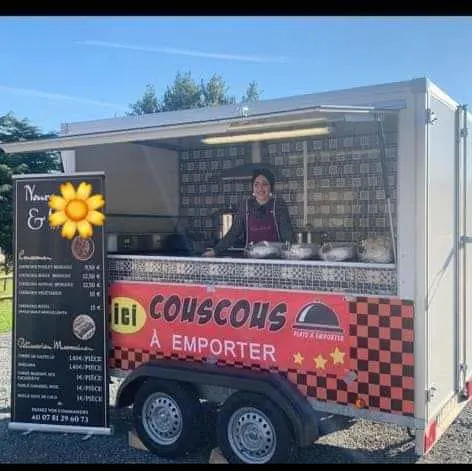 Nora standing inside her Moroccan food trailer, ready to serve couscous